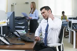Man at desk with sore neck